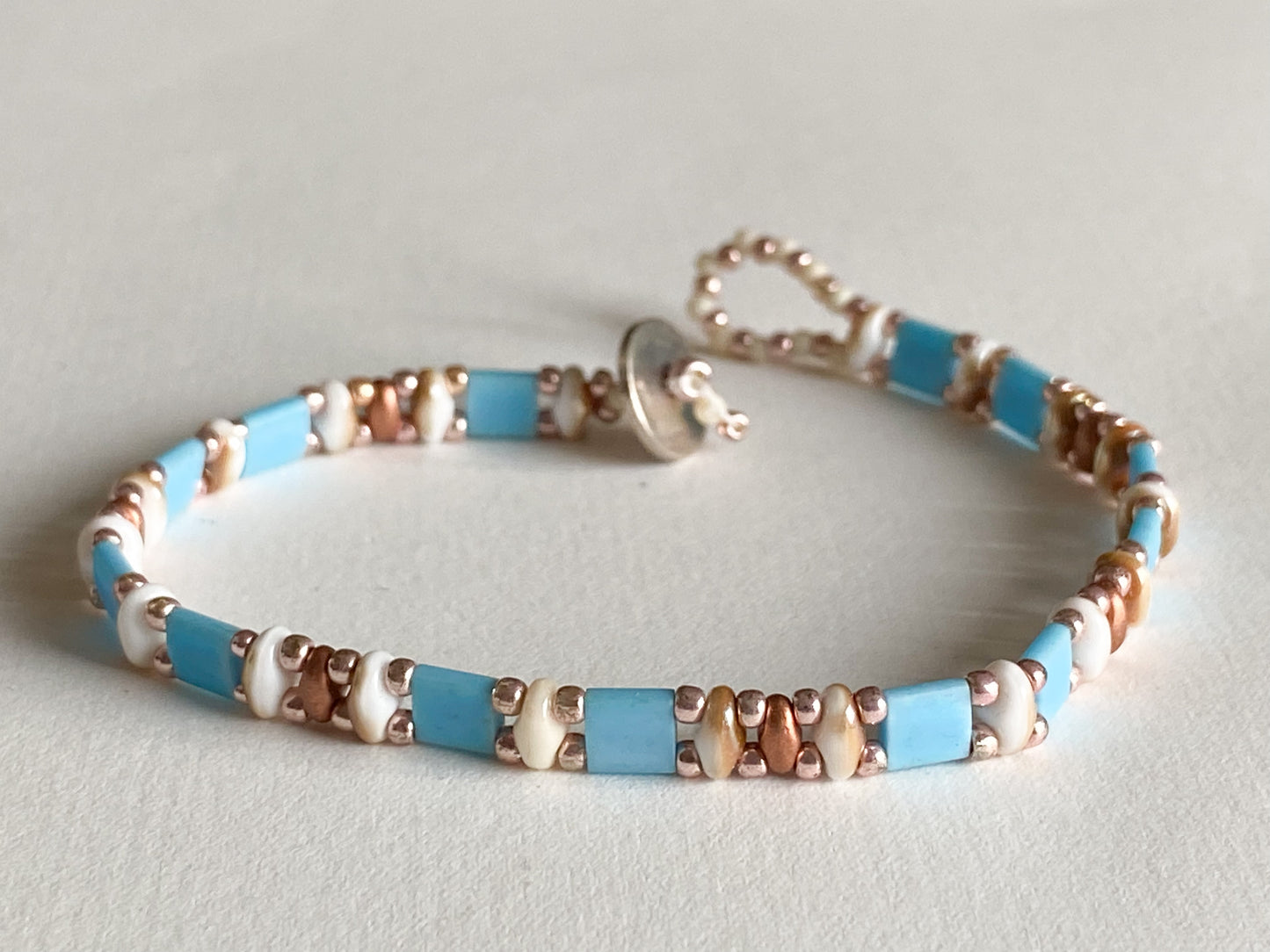 Handgemachtes Armband hellblau Roségold - creme braun mit Knebelverschluss - bohoschmuck Sabetti