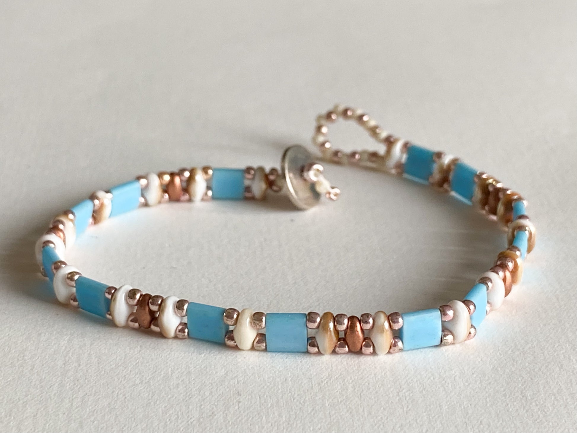 Handgemachtes Armband hellblau Roségold - creme braun mit Knebelverschluss - bohoschmuck Sabetti